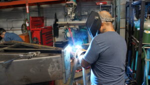 Welder performing metal fabrication in Las Vegas shop, showcasing Statement Fabrication's skilled craftsmanship.