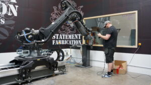 CNC foam carving machine sculpting large foam blocks for scenic fabrication and themed environments.