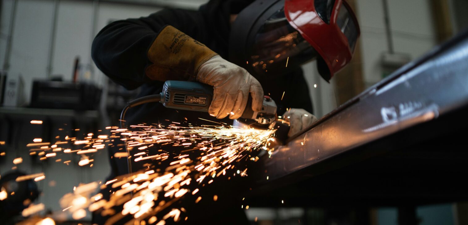 Metal fabrication process with sparks and welding equipment.