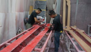 Fiberglass fabrication process in progress, skilled craftsmen working on custom fiberglass components.